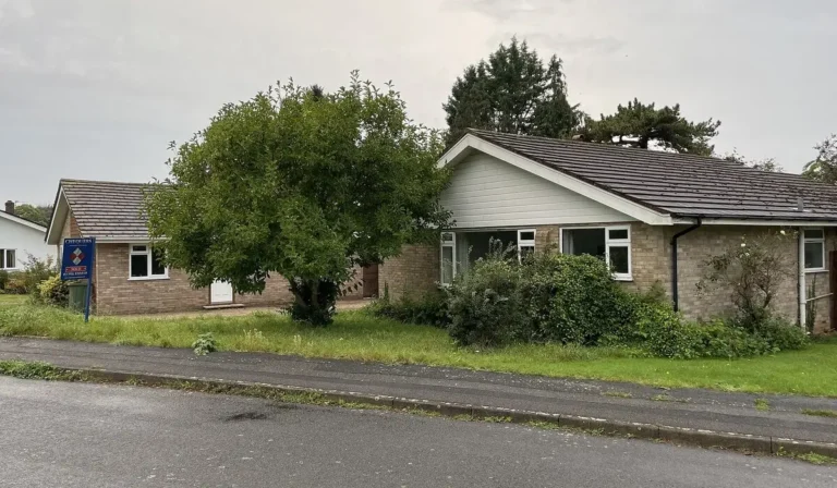 Home buying survey example, a sold bungalow with an estate agent board awaiting new owners